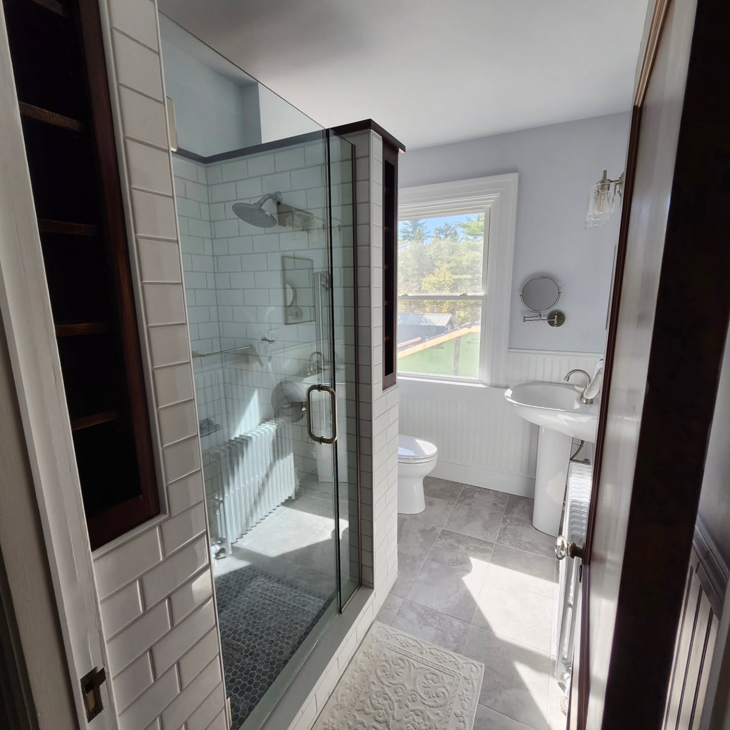 Renovated bathroom with a tiled glass-enclosed shower